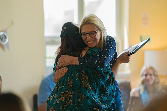 former director Cathy Yura hugging scholarship recipient at WVU Collegiate Recovery graduation celebration